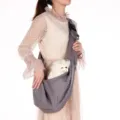 Bandolera gris transpirable para mascotas llevada por una modelo con un perro blanco detalle - Estilo Ajustable con Bolsillo de Lona / Gris