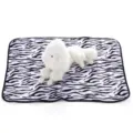 Detailed view of soft zebra patterned fleece pet blanket with a cute plush dog toy display prop. - Zebra Print