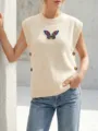 Detailed view of cream knitted vest with sequin butterfly patch and side buttons - S / Tops / Apricot