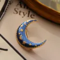 Detailed macro view of a vintage blue enamel crescent moon brooch with golden stars. - Moon Style