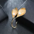 Macro view of vintage matte gold calla lily flower brooch featuring two elegant white pearls - Gold Double Calla Lily Style
