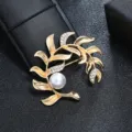 Close-up of a vintage gold leaf brooch with crystals and a white pearl detail. - Gold Branched Leaf Single Pearl Style