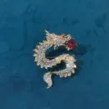 Detailed macro shot of vintage gold-plated dragon brooch with sparkling red crystals - Red Dragon