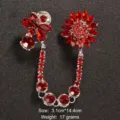 Vista dettagliata di un'elegante spilla vintage con strass rossi e catena pendente. - Stile Catena Lunga Rossa (Stile 19)