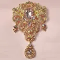 Detailansicht einer goldenen Kronenbrosche mit rosa Tropfensteinen und Strasssteinen. - Goldene Basis Rosa Lila Strass (S1)