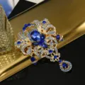 Exquisites Detail einer Vintage-Goldbrosche mit blauen Kristallen und Tropfenanhänger - Goldene Basis Dunkelblauer Strass (S2)