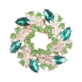Nahaufnahme der zweilagigen Kristall-Blumenkranz-Brosche mit grünen Strasssteinen - Green and White on Gold