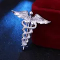 Detailansicht einer silbernen Caduceus-Brosche mit Engelsflügeln und zwei Schlangen - Silber