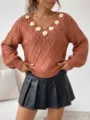 Detailed close-up of brown knit sweater with 3d daisy flowers and black pleated leather skirt. - S / Tops / Brown