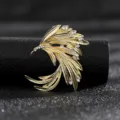 Detailed view of an elegant vintage golden wing brooch with sparkling rhinestones. - Style 1 (Gold Feather)