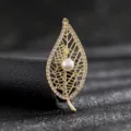 Close-up of elegant golden leaf brooch featuring a central pearl and crystals - Style 7 (Gold Hollow Pearl Leaf)