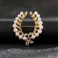 Elegant vintage golden wreath brooch featuring white pearls and a classic bow detail. - Style 12 (Gold Wheat Wreath Pearl)