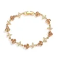 Macro detail of elegant gold-plated clover and butterfly bracelet with sparkling zircon stones - Gold Champagne Zirconia