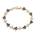 Close-up of golden bracelet with blue clover and crystal butterfly charms - Gold Blue Stone