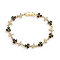 Detail view of gold-tone bracelet with black clover and butterfly cubic zirconia charms - Gold Black Zirconia