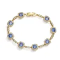 Detailed macro shot of gold bracelet with sparkling blue stones in halo setting. - Gold Blue Stone