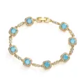 Close-up of golden bracelet with square-cut blue stones and sparkling zircon halo. - Gold With Turquoise Style