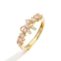 Detailed close-up of a golden adjustable ring featuring a pink crystal bow and stones. - Gold Pink Zirconia Bowknot Ring