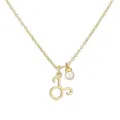 Close-up detail of a gold Taurus zodiac pendant necklace with a white pearl charm - Taurus
