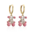 Vue macro détaillée des boucles d'oreilles ours doré avec émail rose et zircons brillants - Rose