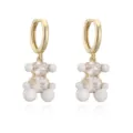 Détail de boucles d'oreilles ours avec des pierres claires et une finition en émail blanc. - Blanc