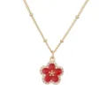 Detaillierte Nahaufnahme einer vergoldeten Kette mit rotem Emaille-Blumenanhänger und Kristallen - Gold Rote Blume Halskette