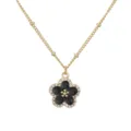 Detailansicht einer goldfarbenen Halskette mit schwarzem Emaille-Blütenanhänger - Gold Schwarze Blume Halskette