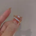 Vista dettagliata di un raffinato set di due anelli dorati con zirconi a forma di cuore - Set di Anelli in Zirconia a Cuore (5690201)