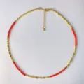 Detaillierte Makroansicht der roten Kristallperlen und goldenen Metallwürfel-Halskette - Rot