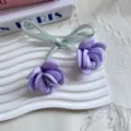 Dettaglio accessorio floreale rosa satin viola con nastro verde su vassoio bianco - Viola