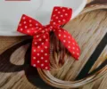 Gros plan d'un petit nœud en satin rouge à pois blancs pour l'emballage de cadeaux - Rouge
