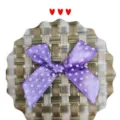 Détail d'un nœud en ruban de satin violet à pois fait main pour emballage cadeau - Violet