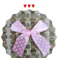 Vue détaillée d'un nœud en satin rose fait main avec des pois blancs pour cadeaux - Rose
