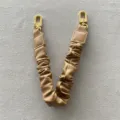 Nahaufnahme von khakifarbenem Leder-Handtaschenriemen mit Goldschließen - Lange Version / Braun