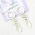Detail shot of white metal spring ring keychain, durable clasp hook accessory for bags. - Beige