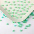 Vue détaillée de charms de petites fleurs en résine pour le nail art et la déco coque DIY. - 05