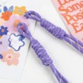 Detail shot of purple braided nylon rope lanyard charms on a decorative background - 1 Piece/Pack / Purple