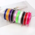 Vista detallada de cordones elásticos de cuentas de cristal coloridos en varios tonos vibrantes. - 10 bandejas (una de cada color)