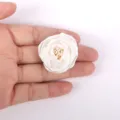 Gros plan détaillé d'une rose en tissu 3D blanche pour accessoires de mariage DIY - Blanc