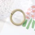 Primer plano detalle de un cierre de anillo de resorte de metal pintado de beige, liso. - Caqui Claro