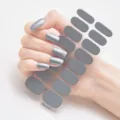 Detalle de 16 pegatinas de uñas de plata metálica aplicadas en una mano y una lámina - Gris Acero Metálico (RM013)
