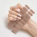 Primer plano detallado de pegatinas de uñas color moca metálico en uñas y la hoja - Mocha Metálico (RM018)