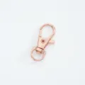 Close-up detail of a rose gold alloy lobster clasp accessory for bags and keychains - Rose Gold