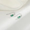 Dettaglio macro di eleganti orecchini a gancio con zircone verde smeraldo rettangolare - Gancio per Orecchio in Zircone Quadrato Verde (Colore Platino)
