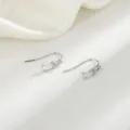 Dettaglio di orecchini d'argento con zircone rettangolare in un design minimalista. - Gancio per Orecchio in Zircone Quadrato Trasparente (Colore Platino)