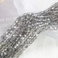 Macro view of 4mm grey AB faceted bicone glass crystal beads for DIY jewelry making - 4mm Approx 70 Pieces/Strand / Transparent Gray