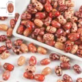 Detail view of printed large-hole natural wood barrel beads with vintage red patterns for DIY jewelry. - Rice Bead (12x8mm) / 50 Pieces/Pack