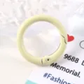 Primer plano de un anillo de resorte crema de 23 mm hecho de aleación de zinc pintada - Beige (FL0739)
