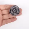 Close-up view of a handmade grey burnt-edge 3D fabric rose flower DIY accessory - Gray