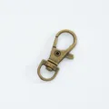 Detailed macro view of an antique bronze lobster claw clasp with swivel D-ring for bags. - Antique Bronze